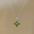 Detail shot of a vintage-style silver necklace featuring a green zircon flower pendant - Silver-Green