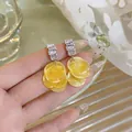 Detailed view of luxury geometric zirconia earrings with yellow layered shell discs - Yellow