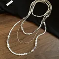Detailed close-up of a four-piece layered pearl necklace set with silver cross charms - Cross Pearl Set / Silver
