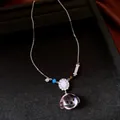 Gedetailleerd overzicht van een zilveren ketting met roze hondenpenning van hars en zirkoon. - Zilver-Roze