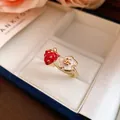 Detailed close-up of a sweet strawberry and flower enamel open ring in a gift box - White
