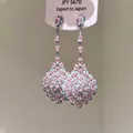 Gros plan d'élégantes boucles d'oreilles pendantes en pierres roses et bleues. - Style Gemme Rose Bleu Goutte Vintage