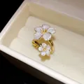 Macro view of a gold-toned flower ring with white pearly petals in a luxury box - Beige