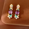 Close-up detail of vintage-style purple zircon earrings with turquoise enamel - Silver Earring Post - Gold - Purple