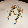 Macro view of colorful marquise-cut crystal tassel earrings in gold-tone setting - Green - Blue