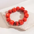 Macro view of red marbled acrylic elastic bracelet featuring round and square beads - Red