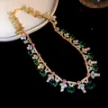 Nahaufnahme einer eleganten vergoldeten Halskette mit grünem Zirkonia und Emaille-Details. - Gold-Grün