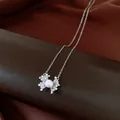 Dettaglio di un elegante ciondolo a fiore in perla con zirconi su catena d'argento. - Collana / Argento