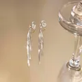 Close-up shot of elegant gold long tassel clip-on earrings featuring a high-shine metallic finish - Clip-on Earrings / One Pair / Silver