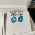 Sparkling bow earrings with blue oval gem pendants in elegant silver finish. - 38# Silver Needle - Silver - Blue