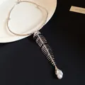 Detailed close-up of a heavy vintage silver fishbone choker necklace with pearl pendant - Necklace / Silver