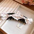 Detailansicht einer eleganten rosa gepunkteten Schleifen-Haarspange im Schmuckfach - Twist Clip / Khaki
