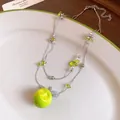 Detailed macro view of double-layered beaded necklace with a vibrant green resin apple pendant - Double Layer Clavicle Chain / Silver-Green