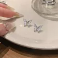 Detailed macro view showing silver-colored butterfly stud earrings inlaid with marquise zircons - Silver