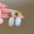 Detail showing green beads and white shell disc tassel dangle earrings for summer - Stud Earrings / Silver / Green-White