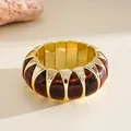 Detailed macro view of vintage amber acrylic and gold segments on a chunky elastic bracelet - Dark Coffee