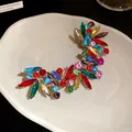 Dettaglio ravvicinato di un ear cuff di lusso con strass colorati e brillanti cristalli. - Polsino dell'Orecchio Integrato / Colorato