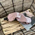 Dettaglio ravvicinato di un fermaglio a banana in raso rosa con eleganti strass lucenti. - Rosa