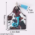 Western cow print leather ear tag keychain featuring blue letter J and tassel decoration - Letter J Style (20136)