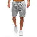 Dettaglio dei pantaloncini sportivi grigi da uomo ad asciugatura rapida con coulisse bianca. - S / Grigio chiaro