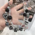 Cordón de teléfono de cuentas hecho a mano con colgante de corazón de cristal negro. - A5-E