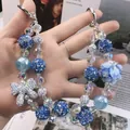 Handmade blue beaded phone strap featuring sparkling bow and floral heart pendant - Klein Blue Rose Heart Style (C2-D)