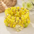 Close-up of yellow bohemian beaded bracelets featuring a multi-language heart charm - Yellow