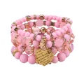 Close-up detail of pink beaded stacking bracelets featuring an engraved gold heart charm - Pink