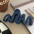 Detail view of a matte navy blue wavy hair claw clip showing its smooth texture - Navy Blue