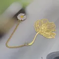 Elegant gold brass bookmark with delicate hollow leaf design and white daisy chain charm - Poppy