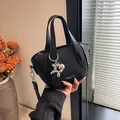 Elegante schwarze Handtasche aus Leder mit Lychee-Struktur und süßem Ballonhund-Anhänger - Schwarz