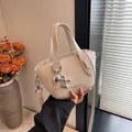 Elegante beige Damenhandtasche mit Lychee-Struktur, Metallic-Hund und verstellbarem Gurt - Gebrochenes Weiß
