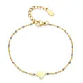 Detailed view of a gold-plated stainless steel bracelet with grey enamel beads and a heart charm. - Gray
