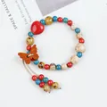 Artistic handmade ceramic beaded bracelet featuring red heart charm and wooden butterfly detail - Moon Style (1786-01) / Multicolor