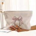 Macro view of a cream corduroy makeup bag featuring a pink bow and baseball print. - Beige Pink Bow Baseball (MR374006)