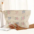Detail of corduroy makeup bag featuring floral and bow prints with a sturdy zipper. - Beige Pink Rose Blue Bow (MU222003)