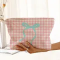 Detailed macro view of pink checkered corduroy makeup bag featuring a large teal bow print - Pink Houndstooth Cyan Bow (RP377270)