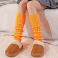 Bright orange thick cable knit leg warmers for women shown in a cozy winter setting - One Size / Orange