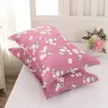Modern pair of pink floral pattern pillowcases displayed on a white bed with flowers - Oracle Brick