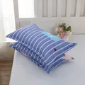 Detailed view of blue striped pillowcases with star pattern on a white bed - Starry Stripe