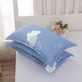 Close-up of modern blue cloud pattern pillowcases pair on a white bed for home use - Cloudy Baby