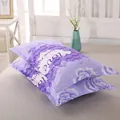 Detailed view of two purple floral pillowcases with love rose print on a bed - Purple Rose