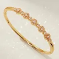 Elegant gold-plated bangle bracelet with shimmering cubic zirconia flower motifs. - Luxury Modern Cuff Bracelet BS-J5638G