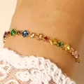 Close-up detail of a colorful rhinestone bracelet on a wrist with lace sleeve - 14k Gold Multicolor Zirconia (9779)