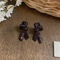 Élégantes boucles d'oreilles nœud avec cristaux rouges scintillants sur monture noire - Noeud Noué / Argent-Noir et Blanc