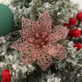 Detail view of rose gold glitter hollow poinsettia flower on a snowy Christmas tree branch - Rose Gold