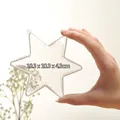 Mano che tiene una pallina di Natale in acrilico trasparente a stella, 10,3x10,3x4,3cm - Esagramma