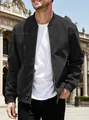 Close-up detail of a men's black suede-like bomber jacket worn by a model in a plaza. - S / Black