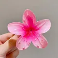 Gros plan d'une pince à cheveux en forme de fleur de frangipanier rose dégradé pour femme - 8cm / Rose