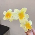 Détail d'une pince à cheveux frangipanier jaune avec des pétales en résine translucide - Triple Fleur / Jaune